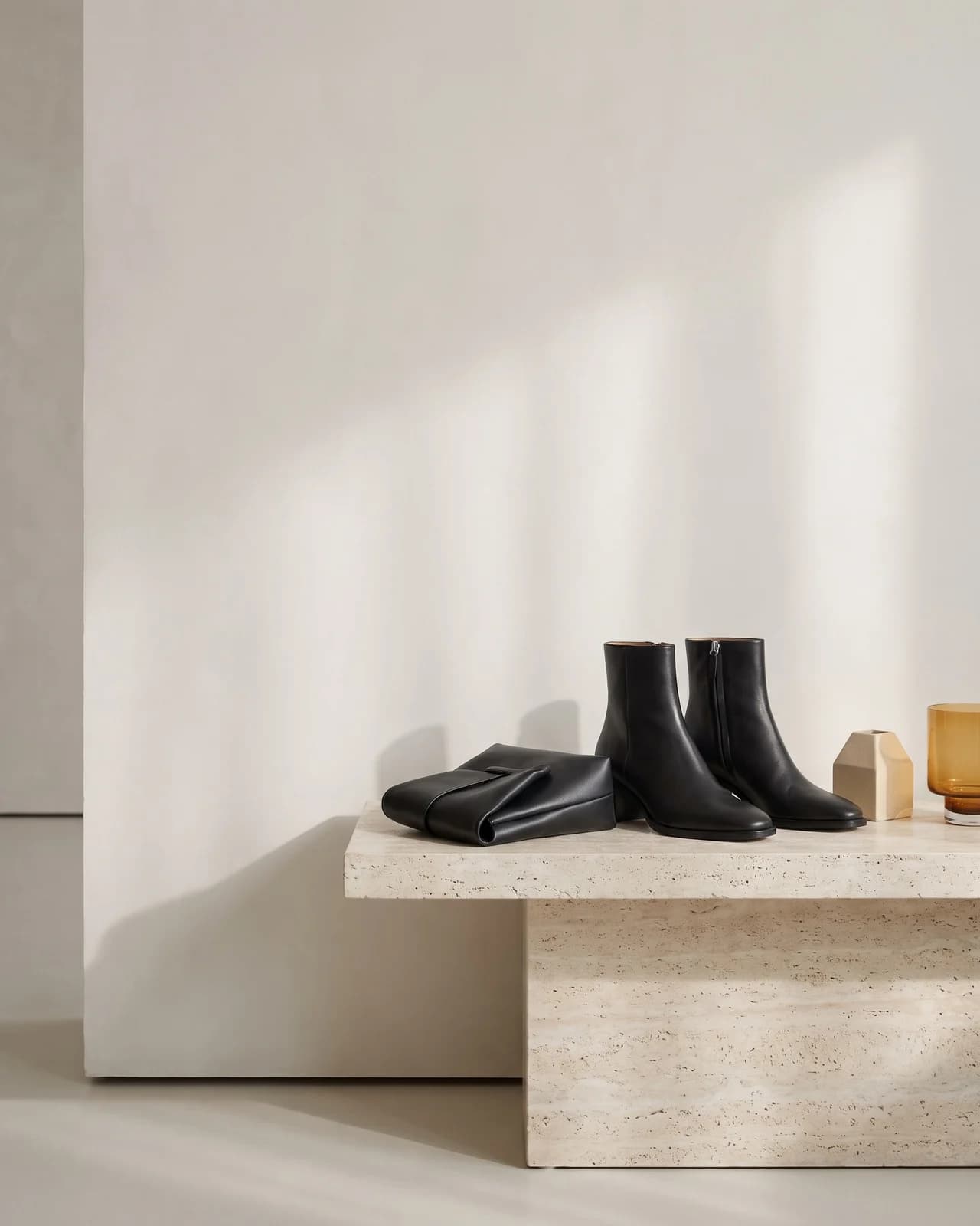 Artisanal leather boots and clutch in architectural setting